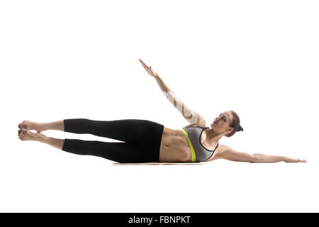 Montare sportivo bella giovane donna in abbigliamento sportivo di Bra e pantaloni neri che lavora fuori, fare esercizio per abs e girovita, gamba laterale Foto Stock