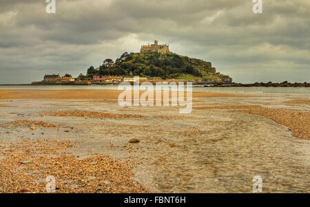 Paesaggio iconico: St Michael's Mount dalla spiaggia dorata sotto la nuvola pesanti Foto Stock