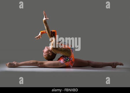 Bella atleta ginnasta ragazza adolescente che indossa la ballerina colorata leotard lavorando fuori, dancing, ponendo, seduta in gruppi Foto Stock