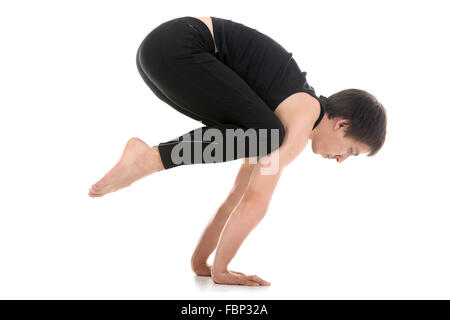 Sporty giovane uomo che lavora fuori, facendo handstand Yoga asana, gru (Crow) pongono, Bakasana per spalle e parte superiore della schiena, braccia e polsi Foto Stock
