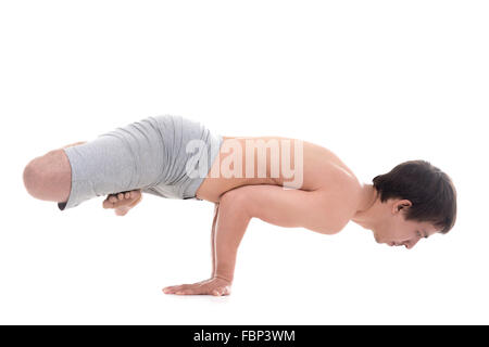 Sporty giovane yoga, pilates, fitness training, braccio facendo esercizio di bilanciamento, handstand, Lotus Peacock pongono, Padma Mayurasana Foto Stock