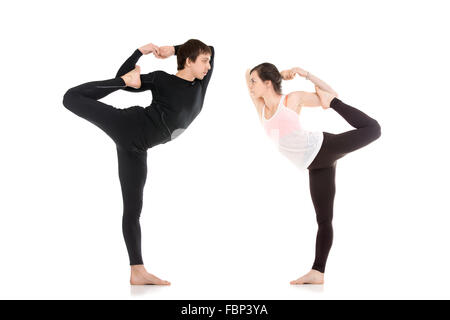 Due persone sportiva pratica yoga in coppia, montare giovane facendo acroyoga, stretching esercizio, asana Maha Natarajasana, re ballerina Foto Stock