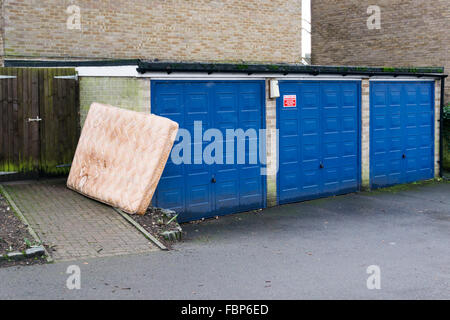 Un vecchio materasso abbandonato in un garage courrt. Foto Stock