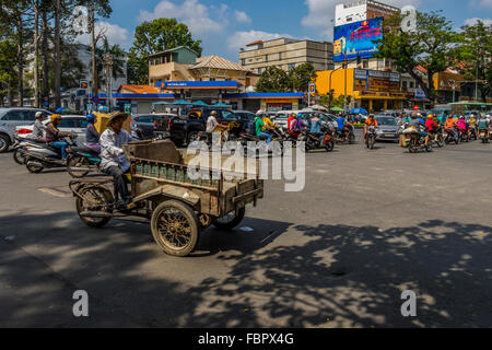 L'uomo sul triciclo carrello su strade trafficate in Vietnam Foto Stock