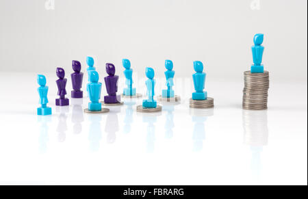 Leadership e struttura aziendale concetto raffigurato con maschio e femail figurine e monete. Il denaro il concetto di distribuzione. Fiera Foto Stock