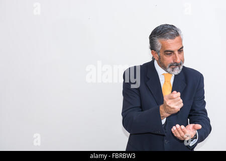 Imprenditore, impegnato nella formazione aziendale. In giacca, agitando mani e sbatte il pugno sull'altra. Foto Stock