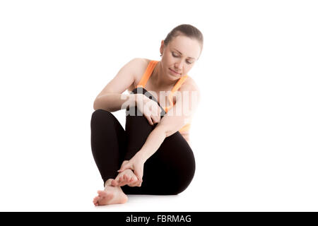 Atleta giovane ragazza in sportswear strofinando il piede, infortunato dopo sport esercizi, sensazione di dolore nel legamento, slogata la caviglia Foto Stock