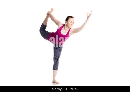 Bella giovane donna facendo Natarajasana, Signore della danza pongono (Dandayamana-Dhanurasana, prua permanente Bikram postura), studio Foto Stock