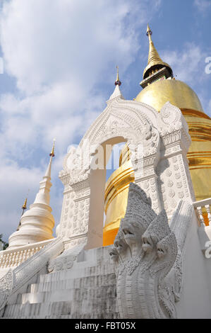 Bianco scultura di serpente & golden stupa, Wat Suan Dok, tempio buddista, Chiang Mai, Thailandia Foto Stock