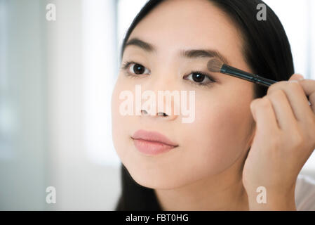 Donna applicando eye shadow Foto Stock