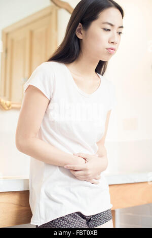 La donna che soffre di dolori di stomaco Foto Stock