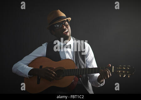 African giovane a suonare la chitarra e cantare Foto Stock