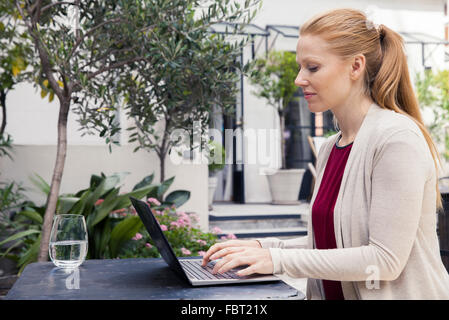 Scrittore utilizzando computer laptop all'aperto Foto Stock