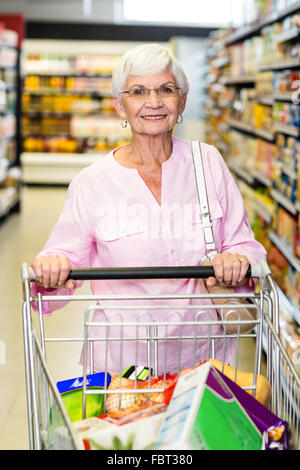 Sorridente donna senior carrello di spinta Foto Stock