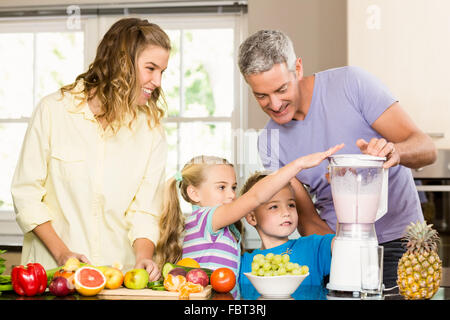 La famiglia felice preparazione frullato sano Foto Stock