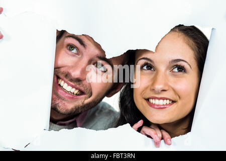 Coppia sorridente che spuntavano carta strappata Foto Stock