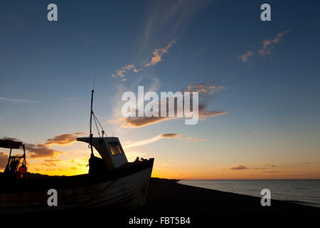 Tramonto sulla Costa North Norfolk a weybourne. barca da pesca di silhouette. Foto Stock