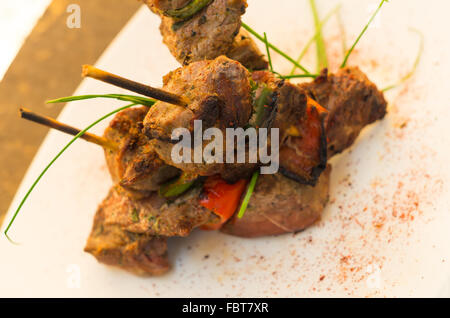 Deliziosi barbecue spiedini di lombata e verdura poste su piastra bianca, elegante presentazione Foto Stock