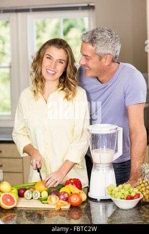 Coppia sorridente preparazione frullato sano Foto Stock