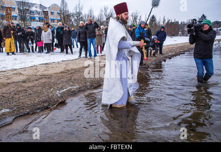 Schwerin, Germania. Xix gen, 2016. Sacerdote Dionisi Idavain immergendo la croce d'oro nell'acqua sulle rive di Schwerin vedere il lago, durante la quarta chiesa russo-ortodossa benedizione delle acque, a Schwerin, Germania, 19 gennaio 2016. Secondo il calendario gregoriano calandra, 19 Gennaio è il giorno del battesimo di Gesù. Foto: Jens BUETTNER/DPA/Alamy Live News Foto Stock