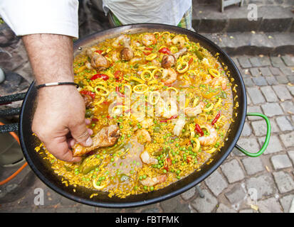 Un cuoco prepara l'uovo con la paella Foto Stock