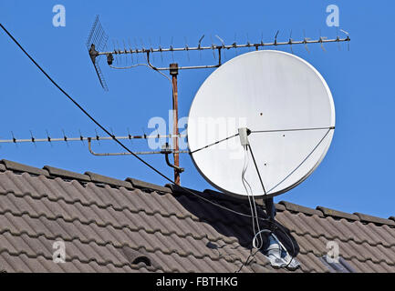 Parabola satellitare e antenna sul tetto di un edificio Foto Stock