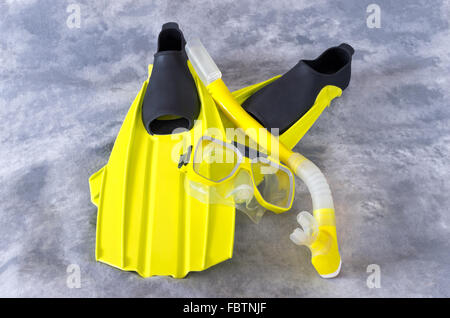 Giallo snorkeling maschera e pinne snorkeling attrezzi isolati contro uno sfondo grigio Foto Stock