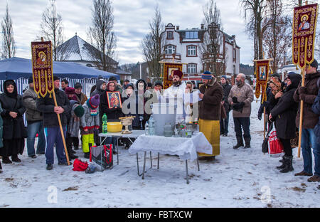 Schwerin, Germania. Xix gen, 2016. Sacerdote russo ortodosso Dionisi Idavain (c) benedice i membri della sua comunità, sulle rive di Schwerin vedere il lago, durante la quarta chiesa russo-ortodossa benedizione delle acque, a Schwerin, Germania, 19 gennaio 2016. Secondo il calendario gregoriano calandra, 19 Gennaio è il giorno del battesimo di Gesù. Foto: Jens BUETTNER/DPA/Alamy Live News Foto Stock