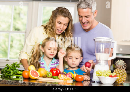 La famiglia felice preparazione frullato sano Foto Stock