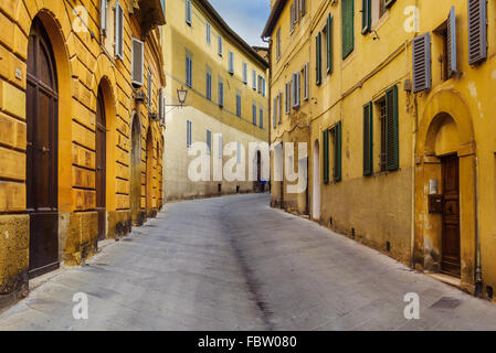 Parete gialla con porta medioevale nella città Toscana Siena Italia Foto Stock
