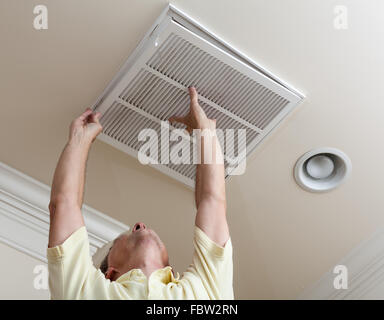 Senior uomo apertura filtro aria condizionata a soffitto Foto Stock