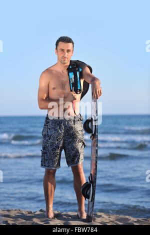 Ritratto di un giovane uomo kitsurf presso la spiaggia sul tramonto Foto Stock