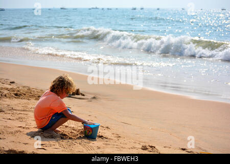 Un bambino gioca con la sabbia. Foto Stock