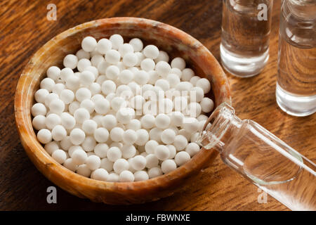 Immagine macro di medicina omeopatica consistente delle pillole (costituito da una sostanza inerte) e bottiglie di liquido omeopatica. Foto Stock