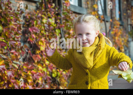 Foglie di autunno come sfondo per un ritratto di una bambina. Foto Stock