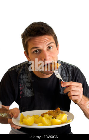 Giovane uomo mangiare cotoletta e patate Foto Stock