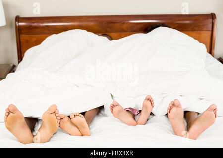 I genitori e i bambini piedi alla fine del letto Foto Stock