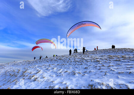 I parapendii circa di decollare da snowy Mam Tor nei pressi di Castleton, Derbyshire, Parco Nazionale di Peak District, Inghilterra, Regno Unito. Foto Stock