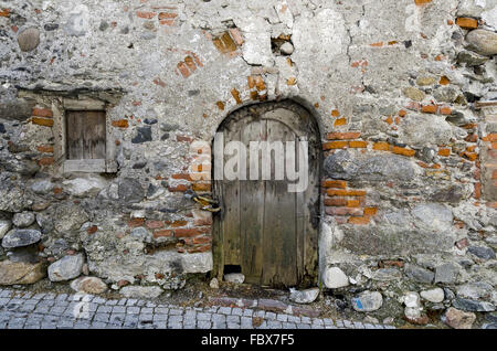La vecchia porta in un vecchio muro Foto Stock