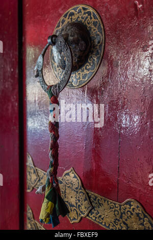 Ornano la maniglia della porta con treccia stoffa colorata decorazione presso il piccolo monastero in città, Bomdila, Arunachal Pradesh, India. Foto Stock