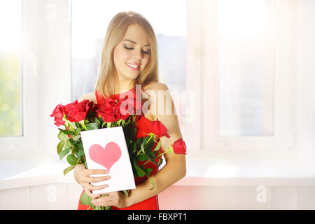 Bellissima ragazza con bouquet di rose rosse Foto Stock