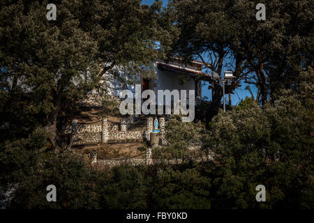 Eremo tra alberi con la Vergine in un pilastro nel villaggio di La Arena, Bilbao, Paesi Baschi. Foto Stock