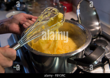 La cottura di polenta gialla in cucina Foto Stock