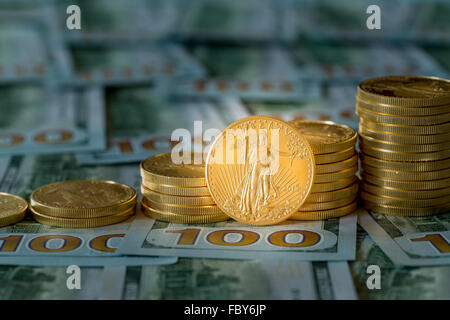 Le monete d'oro impilati sul nuovo design 100 fatture del dollaro Foto Stock