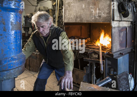 Fabbro lavora su elettro martello Foto Stock