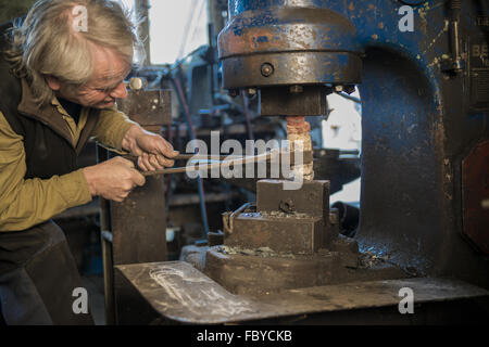 Fabbro lavora su elettro martello Foto Stock