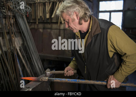 Fabbro lavora su una incudine Foto Stock