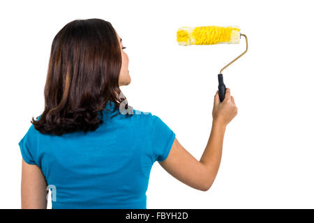 Vista posteriore della donna che mantiene il rullo di vernice Foto Stock