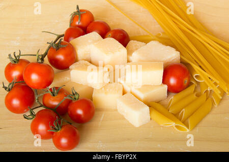 Il Grana Padano italiano, pasta e pomodori su uno sfondo di legno Foto Stock