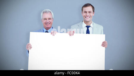 Immagine composita di sorridere i commercianti tenendo premuto segno di vuoto Foto Stock